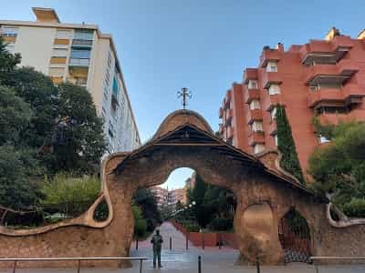 Perspectiva general de la estatua de Gaudí bajo la puerta de la finca Miralles